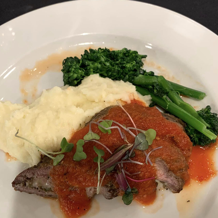 Plate with a hearty serving of meat, creamy mashed potatoes, and fresh broccoli.